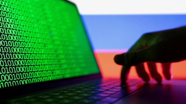 FILE PHOTO: A hand is seen on a laptop with binary code displayed on the screen in front of Russian flag in this picture illustration taken August 19, 2022. REUTERS/Dado Ruvic/Illustration